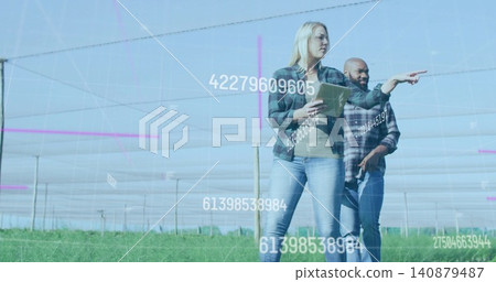 Pointing manager in flannel with tablet, guiding farmer in plaid in netted rows with overlays Pointing manager in flannel with tablet, guiding farmer in plaid in netted rows with overlays 140879487