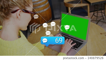 Typing woman in yellow knit sweater wearing tortoise glasses in cafe, viewing laptop bubble 69 140879526
