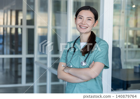 Asian young female doctor smiling nicely and feeling positive Asian young female doctor smiling nicely and feeling positive 140879764