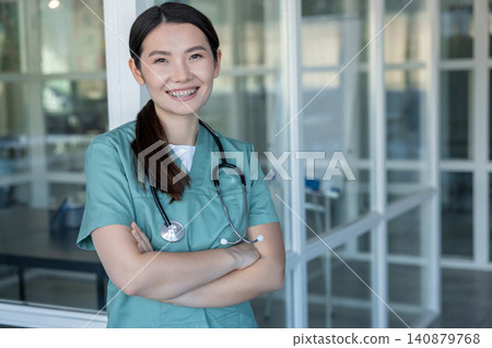 Asian young female doctor smiling nicely and feeling positive Asian young female doctor smiling nicely and feeling positive 140879768