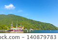 A pirate ship anchored in Lake Ashi in Hakone in early summer, with the mountains covered in fresh greenery and the sky clear blue. 140879783