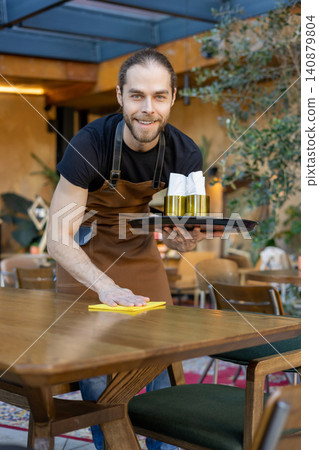 Friendly server cleaning table with yellow cloth Friendly server cleaning table with yellow cloth 140879804