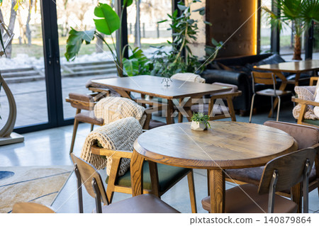 Interior of modern cozy cafe with wooden furniture and plants Interior of modern cozy cafe with wooden furniture and plants 140879864