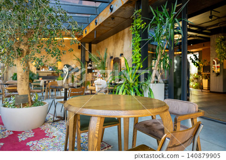 Spacious cafe interior with glass roof and greenery 140879905