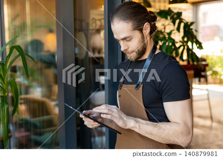 Male server typing on tablet screen Male server typing on tablet screen 140879981