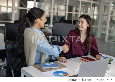 Two young businesswomen shaking hands 140880626