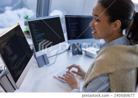 Cheerful woman programmer working with code in office 140880677