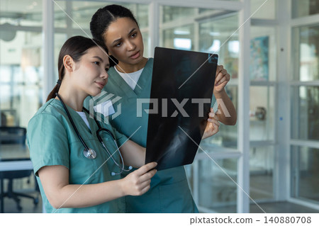 Doctors in clinic analyzing xray results and discussing the diagnosis Doctors in clinic analyzing xray results and discussing the diagnosis 140880708
