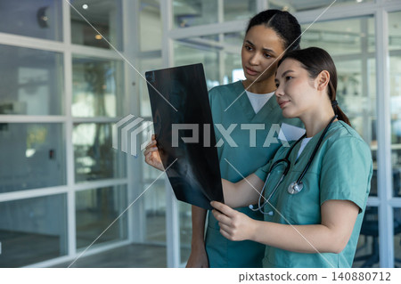Doctors in clinic analyzing xray results and discussing the diagnosis Doctors in clinic analyzing xray results and discussing the diagnosis 140880712