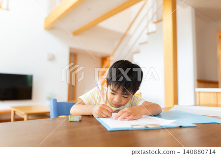 A first-grade boy doing his homework in the living room. A first-grade boy doing his homework in the living room. 140880714
