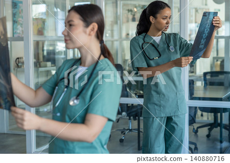 Doctors in clinic analyzing xray results and discussing the diagnosis Doctors in clinic analyzing xray results and discussing the diagnosis 140880716