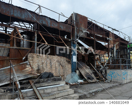 A ruined commercial building stands charred after a fire, displaying rusted metal frames and debris, highlighting urban decay, tragedy, and the aftermath of a devastating disaster event A ruined commercial building stands charred after a fire, displaying rusted metal frames and debris, highlighting urban decay, tragedy, and the aftermath of a devastating disaster event 140881049