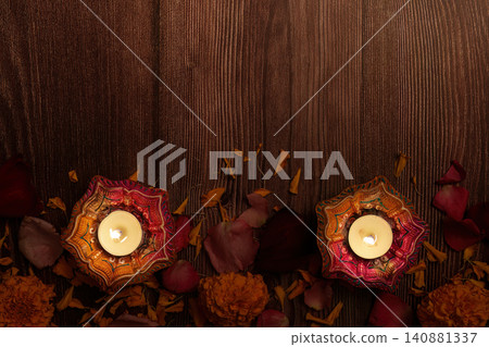 Diwali festival concept with lit clay diyas and marigold flowers on wooden background Diwali festival concept with lit clay diyas and marigold flowers on wooden background 140881337