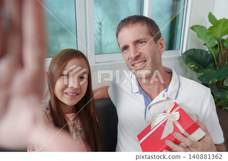 Happy father and daughter taking selfie with gift box on Father's Day Happy father and daughter taking selfie with gift box on Father's Day 140881362