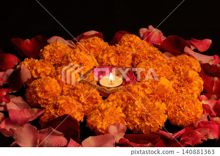 Festive Diwali floral decoration with lit clay diya and marigold flowers Festive Diwali floral decoration with lit clay diya and marigold flowers 140881363