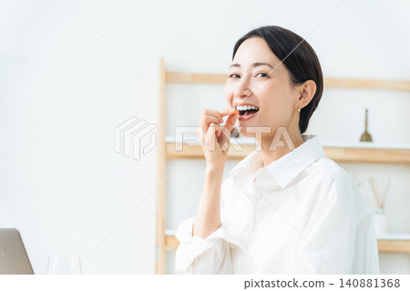A woman taking medicine. Pharmaceuticals, supplements, over-the-counter medications, generics, vitamins, cold medicine, headache medicine, laxatives. A woman taking medicine. Pharmaceuticals, supplements, over-the-counter medications, generics, vitamins, cold medicine, headache medicine, laxatives. 140881368