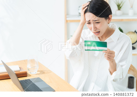A woman looks at her bankbook and worries. Savings, bank, shock, disappointment, worry, trouble, anxiety, concern, dissatisfaction, household finances, money, money A woman looks at her bankbook and worries. Savings, bank, shock, disappointment, worry, trouble, anxiety, concern, dissatisfaction, household finances, money, money 140881372
