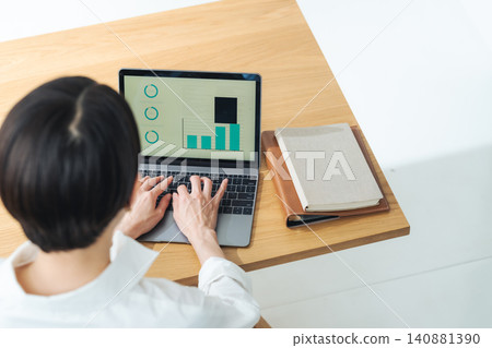 A woman using a laptop. Desk work, DX, work, freelance, working from home, office work, systems, working. A woman using a laptop. Desk work, DX, work, freelance, working from home, office work, systems, working. 140881390
