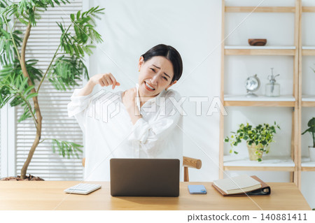 一位中年女性在工作中感到肩膀僵硬。 （關鍵字：疲勞、過度勞累、疲憊、工作、就業、醫療保健、加班、自由工作） 140881411