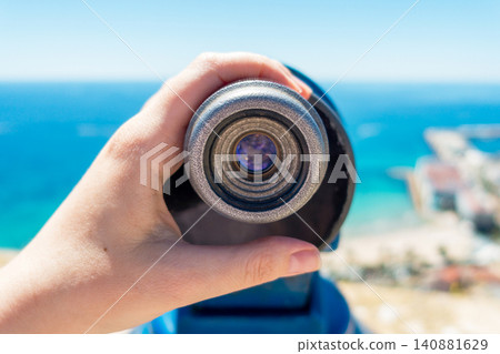 Hand Holding Tourist Viewing Telescope Overlooking Harbor and Sea Hand Holding Tourist Viewing Telescope Overlooking Harbor and Sea 140881629