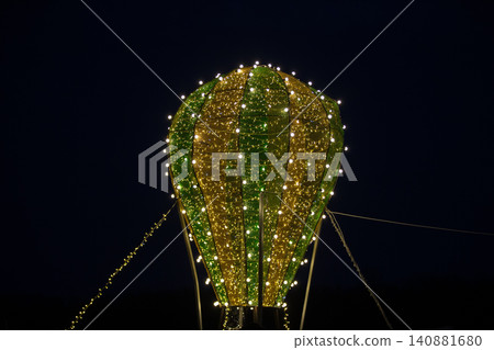 Illuminated hot air balloon decoration shines brightly against the night sky at a festive event Illuminated hot air balloon decoration shines brightly against the night sky at a festive event 140881680