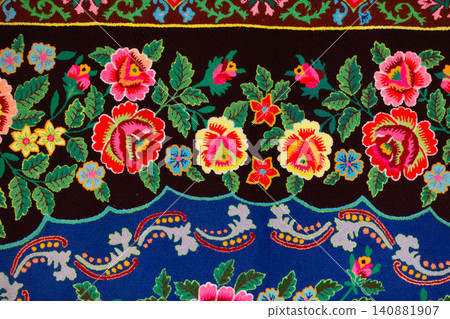 Colorful textiles with intricate floral designs in the Slavic ethnic on a dark background. Colorful textiles with intricate floral designs in the Slavic ethnic on a dark background. 140881907