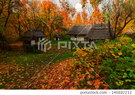 Idyllic autumn scene with traditional log houses and vibrant fall foliage Idyllic autumn scene with traditional log houses and vibrant fall foliage 140882212