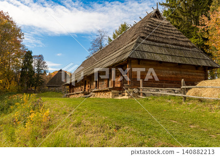 Rustic log cabin settlement nestled in a vibrant autumn countryside landscape Rustic log cabin settlement nestled in a vibrant autumn countryside landscape 140882213