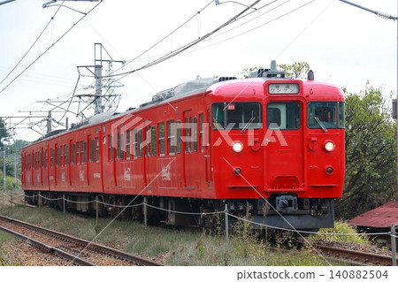 Shinano Railway 115 series train in cola color traveling on a straight section of track. Shinano Railway 115 series train in cola color traveling on a straight section of track. 140882504