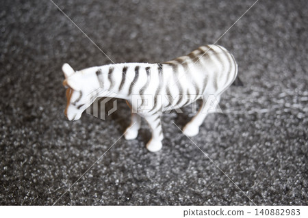 The toy zebra. Plastic toy on the floor. The toy zebra. Plastic toy on the floor. 140882983