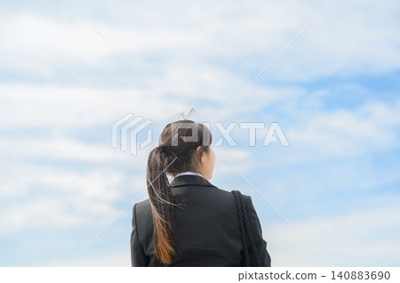 一位二十多歲的日本女性在辦公室工作,背對著鏡頭,抬頭望向天空。 一位二十多歲的日本女性在辦公室工作,背對著鏡頭,抬頭望向天空。 140883690