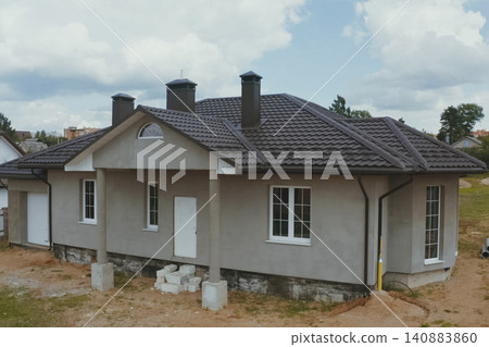 House with a brown metal roof.Corrugated metal roof and metal roofing. Modern roof made of metal. House with a brown metal roof.Corrugated metal roof and metal roofing. Modern roof made of metal. 140883860
