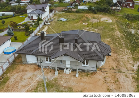 House with a brown metal roof.Corrugated metal roof and metal roofing. Modern roof made of metal. House with a brown metal roof.Corrugated metal roof and metal roofing. Modern roof made of metal. 140883862