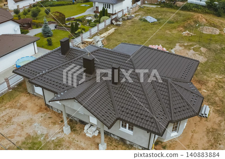 House with a brown metal roof.Corrugated metal roof and metal roofing. Modern roof made of metal. House with a brown metal roof.Corrugated metal roof and metal roofing. Modern roof made of metal. 140883884