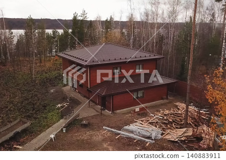 House with a brown metal roof.Corrugated metal roof and metal roofing. Modern roof made of metal. House with a brown metal roof.Corrugated metal roof and metal roofing. Modern roof made of metal. 140883911