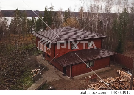 House with a brown metal roof.Corrugated metal roof and metal roofing. Modern roof made of metal. House with a brown metal roof.Corrugated metal roof and metal roofing. Modern roof made of metal. 140883912