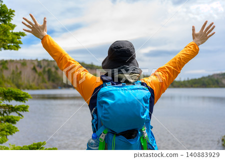 Japanese man with arms outstretched in a lake Japanese man with arms outstretched in a lake 140883929