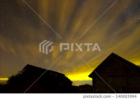 Starry sky over wooden houses in the village. Starry sky background picture of stars in night sky and the Milky Way. Starry sky over wooden houses in the village. Starry sky background picture of stars in night sky and the Milky Way. 140883994
