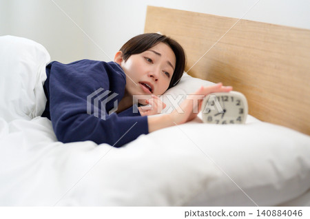 一名日本女子因睡眠不足而關掉了鬧鐘。 一名日本女子因睡眠不足而關掉了鬧鐘。 140884046