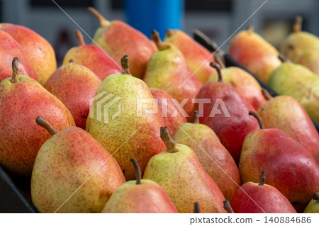 Pears on a food market or supermarket counter. A close-up of fresh, ripe, delicious pears, neatly arranged in a market display. Demonstration of organic vegetarian and healthy food. 140884686