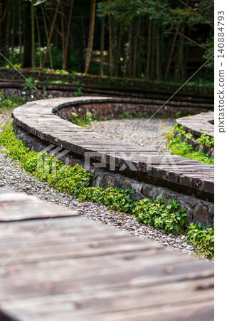 園區螺旋曲線木棧道石牆綠色草坪自然景觀建築設計特寫 園區螺旋曲線木棧道石牆綠色草坪自然景觀建築設計特寫 140884793