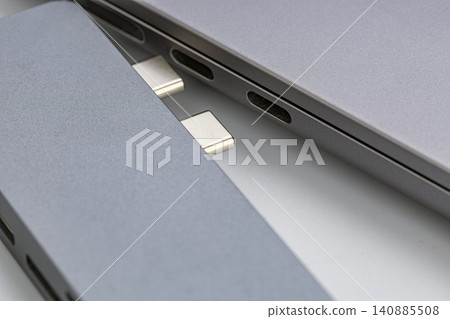 Extreme close up macro shot of two USB Type C connector plugs positioned next to modern silver aluminum laptop ports showing detailed metal contacts and sleek industrial design of universal Extreme close up macro shot of two USB Type C connector plugs positioned next to modern silver aluminum laptop ports showing detailed metal contacts and sleek industrial design of universal 140885508