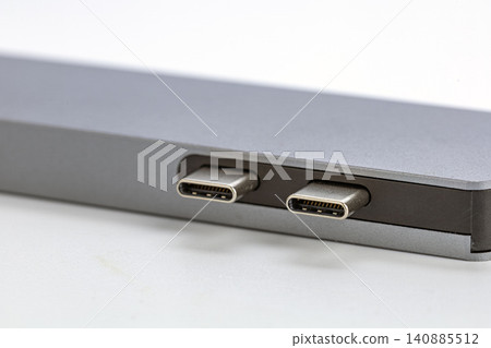 Detailed macro close up shot of two USB Type-C connector ports on the side panel of a sleek modern silver aluminum laptop computer showing metallic contacts and connector pins on a clean white Detailed macro close up shot of two USB Type-C connector ports on the side panel of a sleek modern silver aluminum laptop computer showing metallic contacts and connector pins on a clean white 140885512