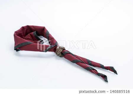 Traditional Thai Scout uniform neckerchief in maroon with black trim secured by a handcrafted leather Turk's Head woggle knot, neatly displayed and isolated on a clean white studio background for Traditional Thai Scout uniform neckerchief in maroon with black trim secured by a handcrafted leather Turk's Head woggle knot, neatly displayed and isolated on a clean white studio background for 140885516