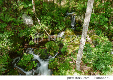 An unnamed stream and waterfall flowing through the forests of Hokkaido; natural scenery featuring moss-covered rocks and clear water. An unnamed stream and waterfall flowing through the forests of Hokkaido; natural scenery featuring moss-covered rocks and clear water. 140886360