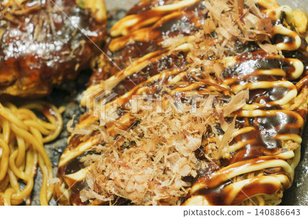 Okonomiyaki grilled on a hot plate with sauce and mayonnaise Okonomiyaki grilled on a hot plate with sauce and mayonnaise 140886643
