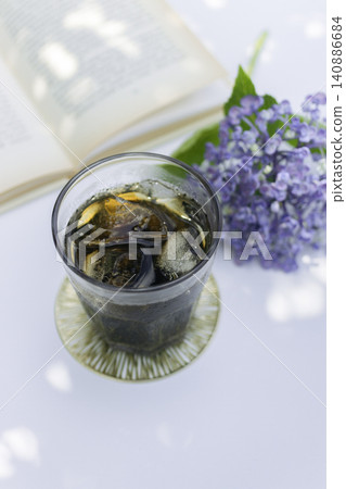 Iced coffee bathed in sunlight filtering through the trees, and hydrangeas – a refreshing table photo evoking the feeling of summer. Iced coffee bathed in sunlight filtering through the trees, and hydrangeas – a refreshing table photo evoking the feeling of summer. 140886684