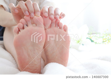 A woman self-checks her toes. A woman self-checks her toes. 140887300
