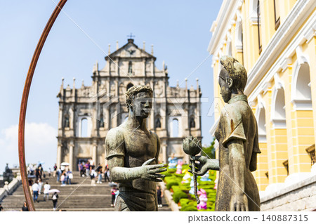 A sculpture of a young man and woman in front of the Ruins of St. Paul's at Jesus Company Square in Macau symbolizes the friendship between China and Portugal. A sculpture of a young man and woman in front of the Ruins of St. Paul's at Jesus Company Square in Macau symbolizes the friendship between China and Portugal. 140887315