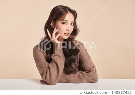 A beautiful young Asian woman with clean, fresh skin against a beige background. Skincare, facial treatment, cosmetology, beauty, and spa. An elegant portrait of an Asian woman. A beautiful young Asian woman with clean, fresh skin against a beige background. Skincare, facial treatment, cosmetology, beauty, and spa. An elegant portrait of an Asian woman. 140887432